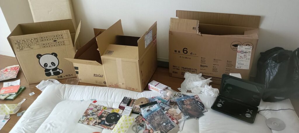 買取業者の段ボールに本やディスクを詰めている
